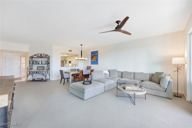 living room with ceiling fan with notable chandelier and carpet floors