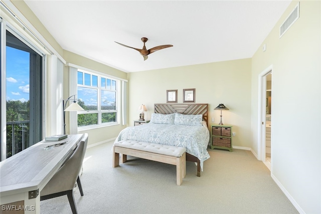 carpeted bedroom with ensuite bathroom and ceiling fan