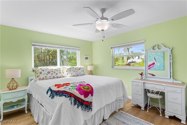 bedroom featuring light wood-type flooring, multiple windows, and ceiling fan