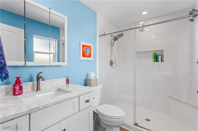 bathroom with walk in shower, vanity, and toilet