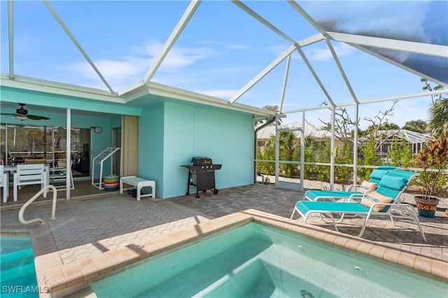 view of pool with a hot tub, glass enclosure, a patio, grilling area, and ceiling fan