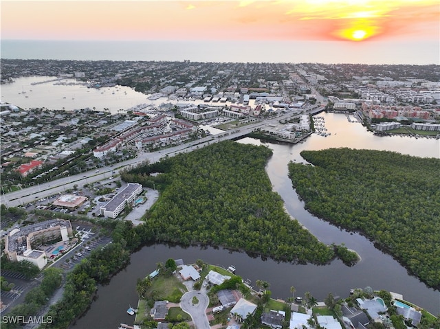 aerial view at dusk featuring a water view