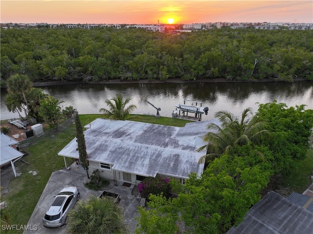 aerial view at dusk featuring a water view