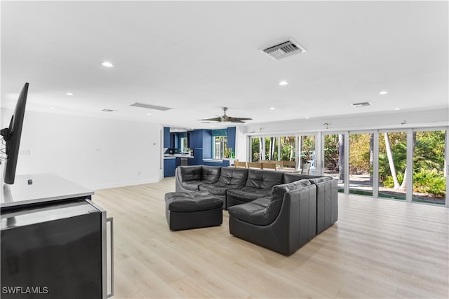 living room featuring light hardwood / wood-style flooring and ceiling fan