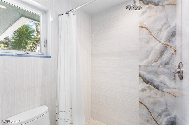 bathroom featuring a shower with shower curtain and toilet