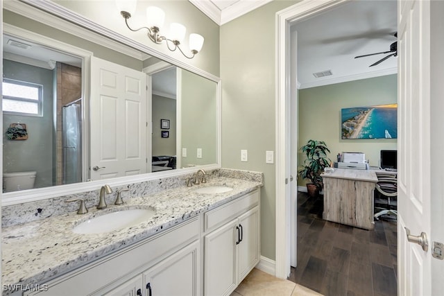 bathroom featuring toilet, hardwood / wood-style floors, ornamental molding, vanity, and walk in shower