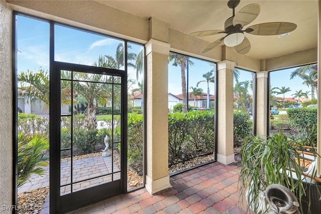 unfurnished sunroom featuring ceiling fan