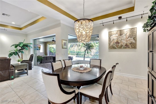 dining space featuring light tile patterned flooring, ceiling fan with notable chandelier, a raised ceiling, and ornamental molding