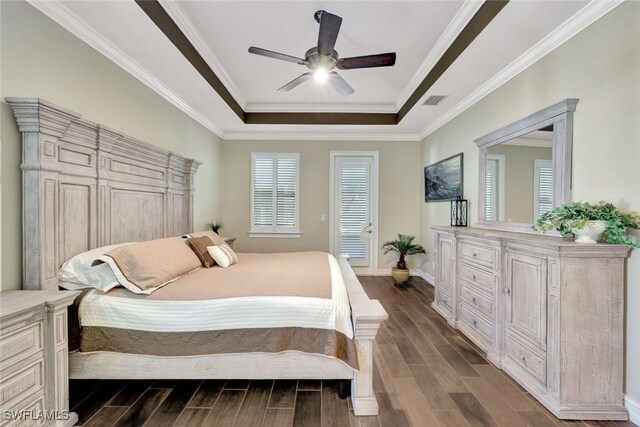 bedroom featuring dark hardwood / wood-style flooring, a tray ceiling, ceiling fan, and crown molding