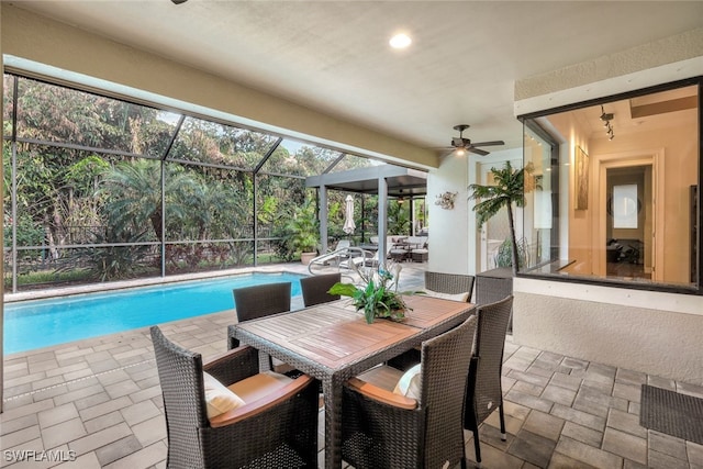 view of swimming pool with ceiling fan, a lanai, and a patio