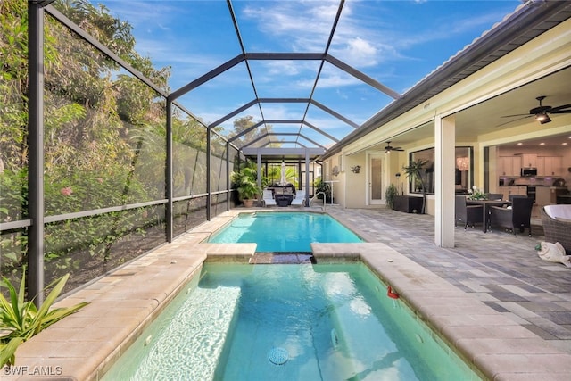 view of pool featuring a patio, ceiling fan, glass enclosure, and an in ground hot tub