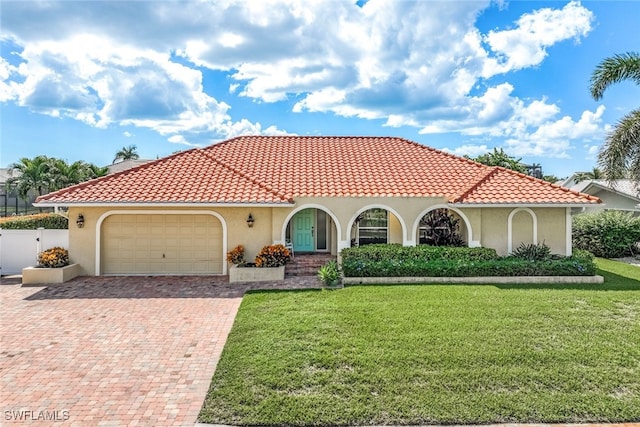 mediterranean / spanish-style house featuring a front lawn and a garage