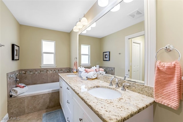 bathroom with tile patterned floors, vanity, and a relaxing tiled tub