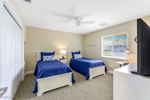 carpeted bedroom featuring ceiling fan and a closet