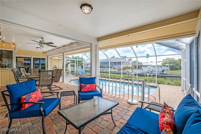 sunroom / solarium featuring a swimming pool, ceiling fan, and track lighting