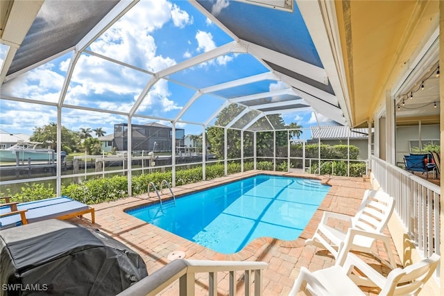 view of pool with a patio and glass enclosure