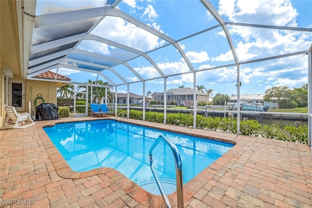 view of swimming pool featuring a lanai, a water view, and a patio area