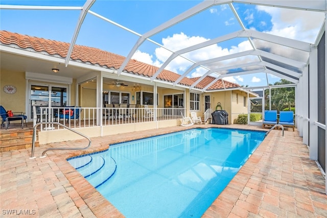 view of pool with ceiling fan, a lanai, and a patio area