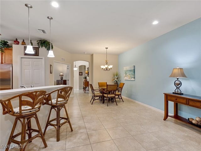 dining area with a chandelier and light tile patterned floors