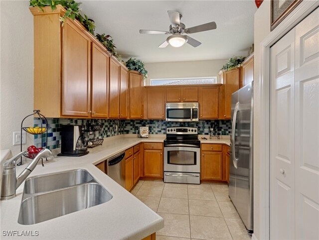 kitchen with decorative backsplash, ceiling fan, appliances with stainless steel finishes, light tile patterned flooring, and sink