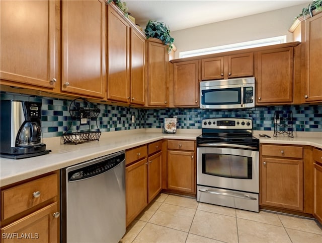 kitchen featuring tasteful backsplash, stainless steel appliances, and light tile patterned floors