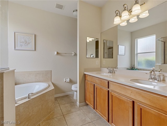 bathroom featuring vanity, tiled tub, toilet, and tile patterned floors