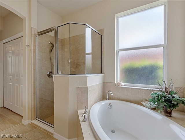 bathroom with a healthy amount of sunlight, tile patterned floors, and shower with separate bathtub