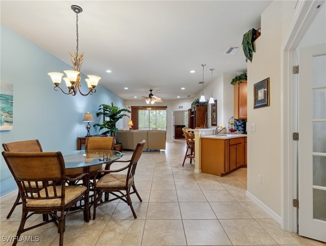 dining area featuring light tile patterned flooring and ceiling fan with notable chandelier