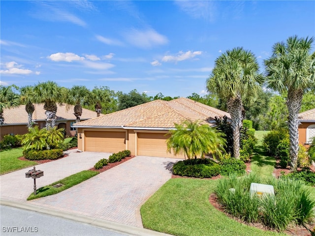 mediterranean / spanish-style house featuring a front yard and a garage