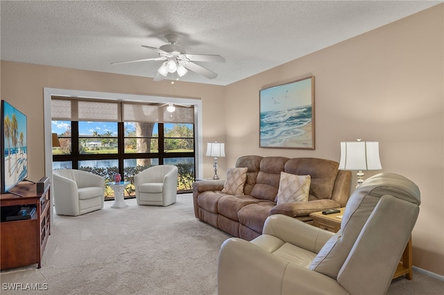 carpeted living room featuring a textured ceiling, a water view, and ceiling fan