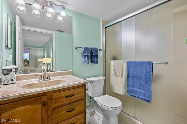 bathroom featuring vanity, toilet, and an enclosed shower