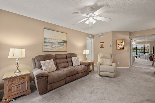 carpeted living room with a textured ceiling and ceiling fan