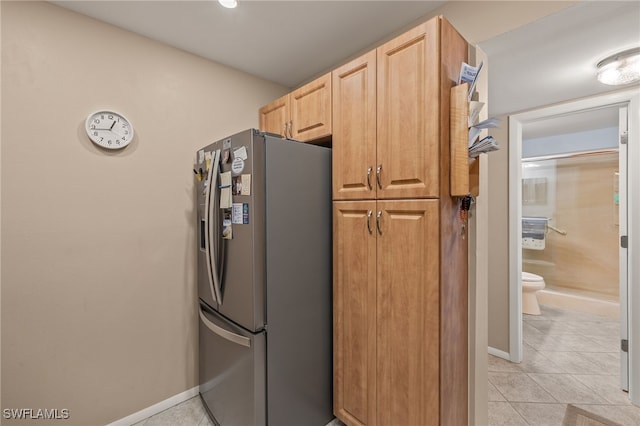 kitchen featuring stainless steel fridge with ice dispenser, light brown cabinets, and light tile patterned floors