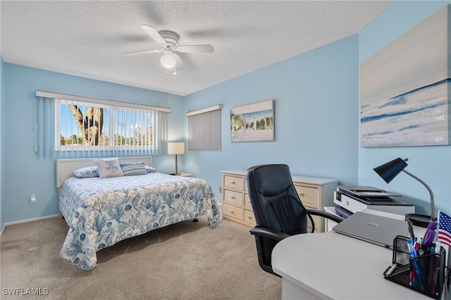 carpeted bedroom with ceiling fan and a textured ceiling