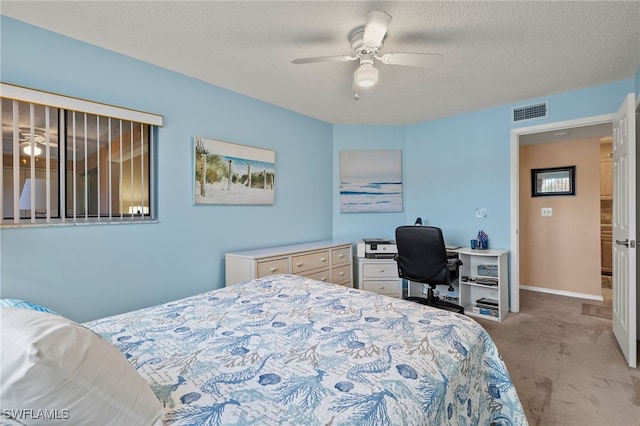 bedroom with a textured ceiling, ceiling fan, and light carpet