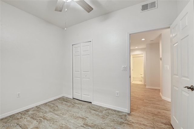 unfurnished bedroom featuring ceiling fan and a closet