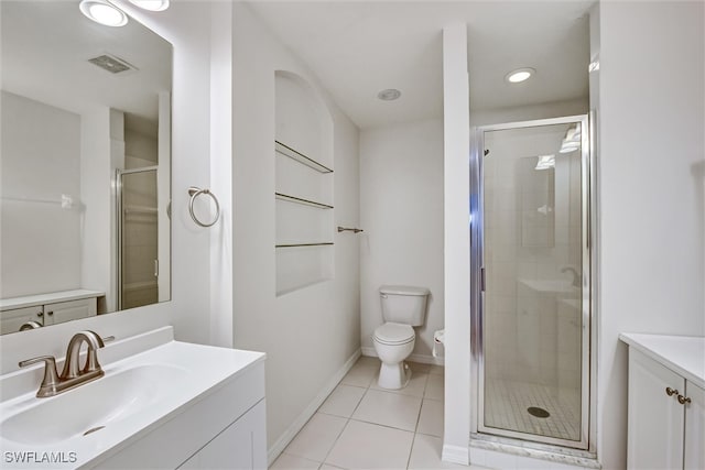 bathroom featuring tile patterned floors, vanity, a shower with shower door, and toilet