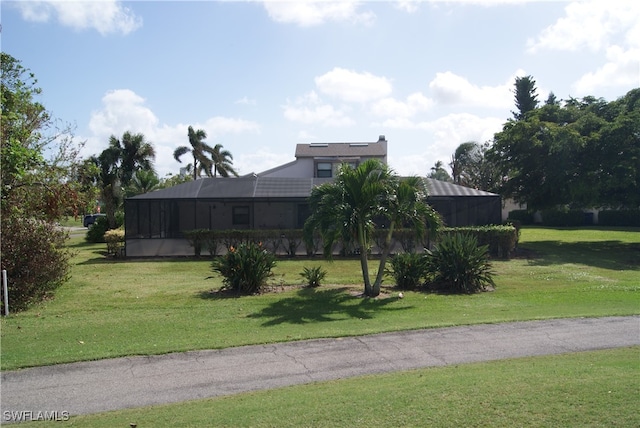 view of front facade featuring glass enclosure and a front lawn