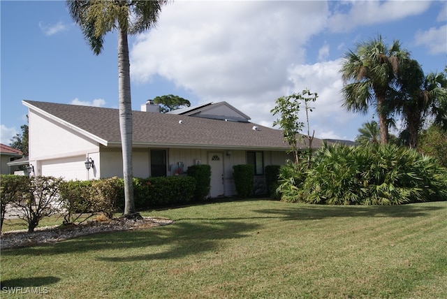 single story home with a garage and a front lawn