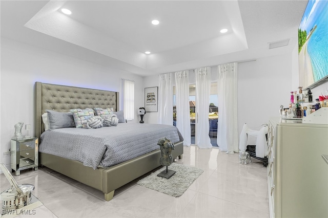 bedroom with washer / dryer, access to outside, and a tray ceiling