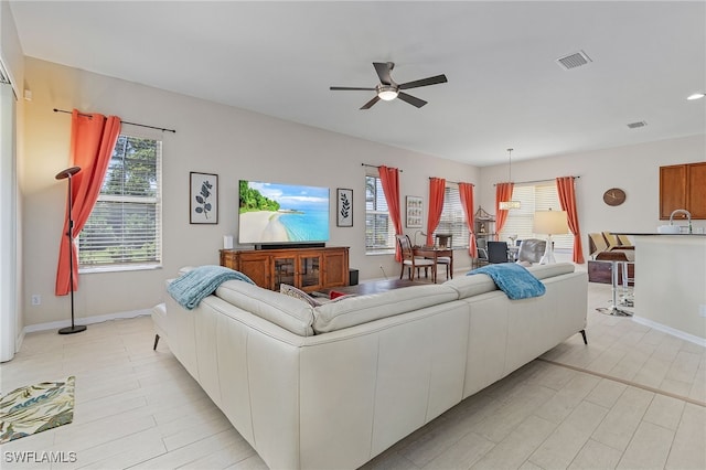 living room featuring ceiling fan and sink