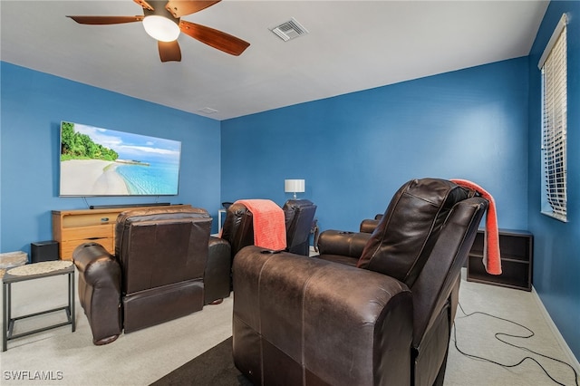 carpeted home theater room with ceiling fan