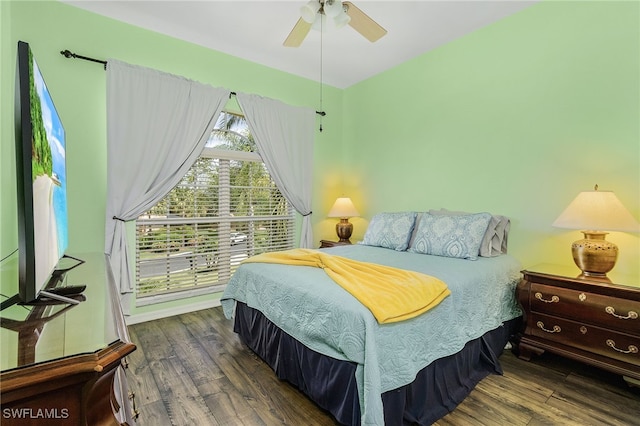 bedroom with dark hardwood / wood-style flooring and ceiling fan