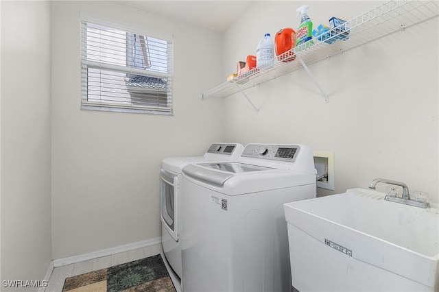 clothes washing area with sink and independent washer and dryer