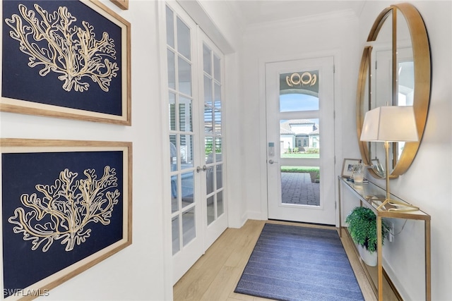 doorway to outside with ornamental molding, light hardwood / wood-style flooring, and french doors