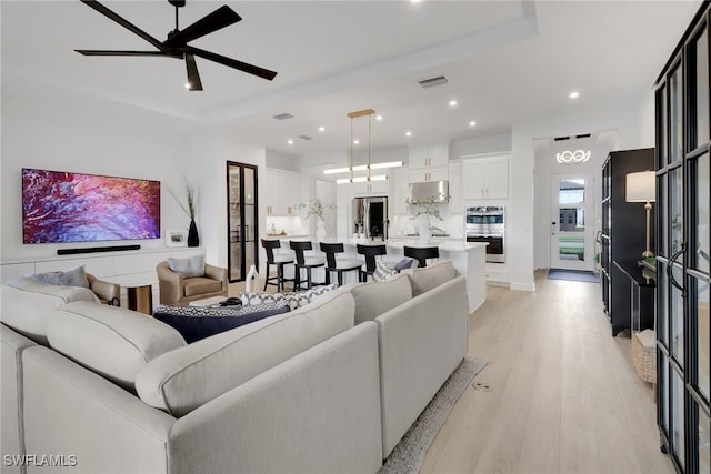 living room featuring light hardwood / wood-style flooring and ceiling fan