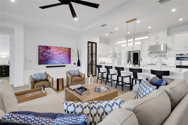 living room with ceiling fan and light wood-type flooring