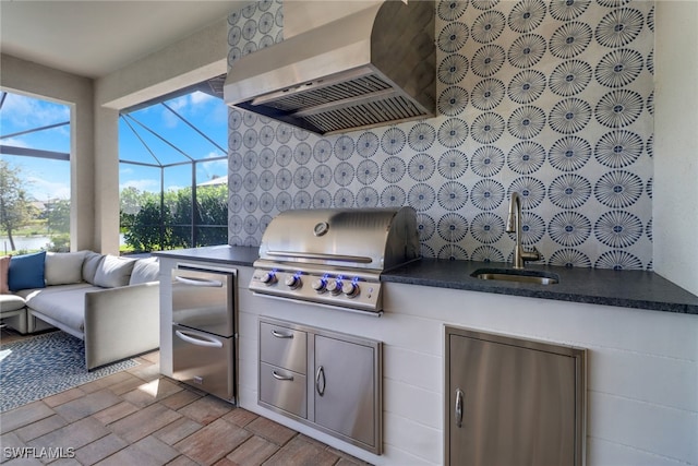 view of patio / terrace featuring glass enclosure, area for grilling, exterior kitchen, and sink