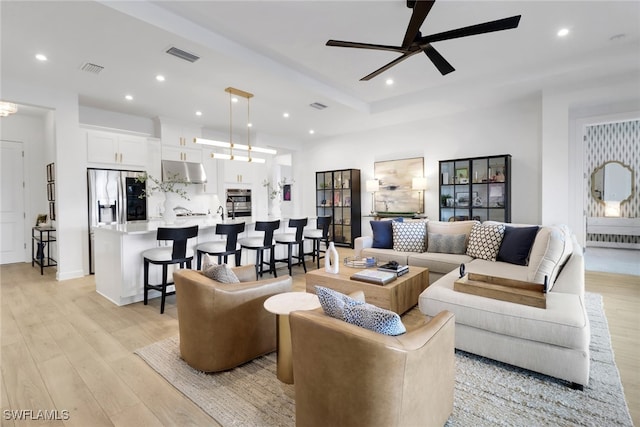 living room featuring ceiling fan and light wood-type flooring