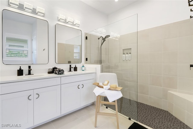 bathroom with tile patterned floors, vanity, and a tile shower